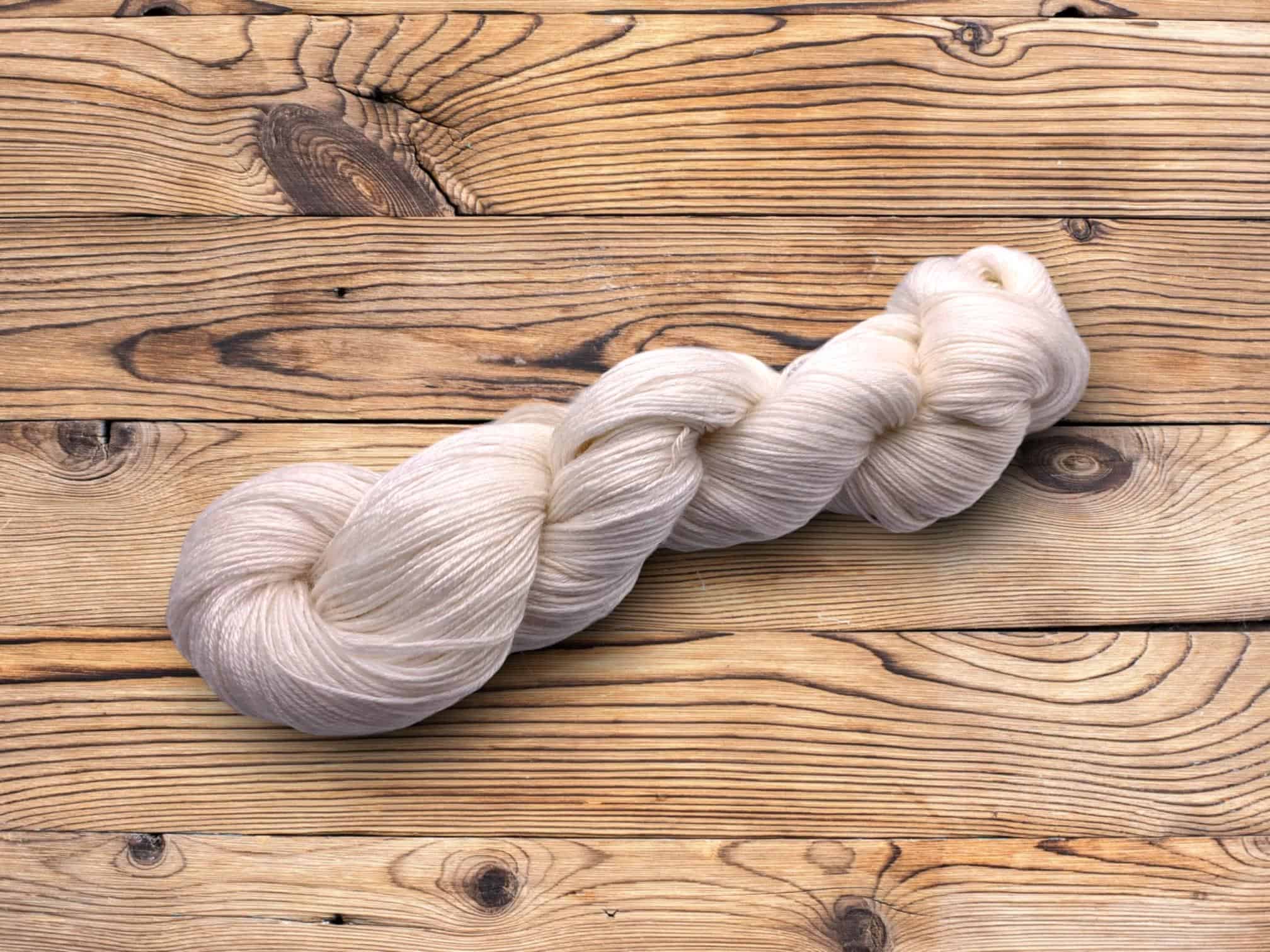 49105 Bamboo Viscose 4 Ply A skein of undyed bamboo yarn photographed on a wood background
